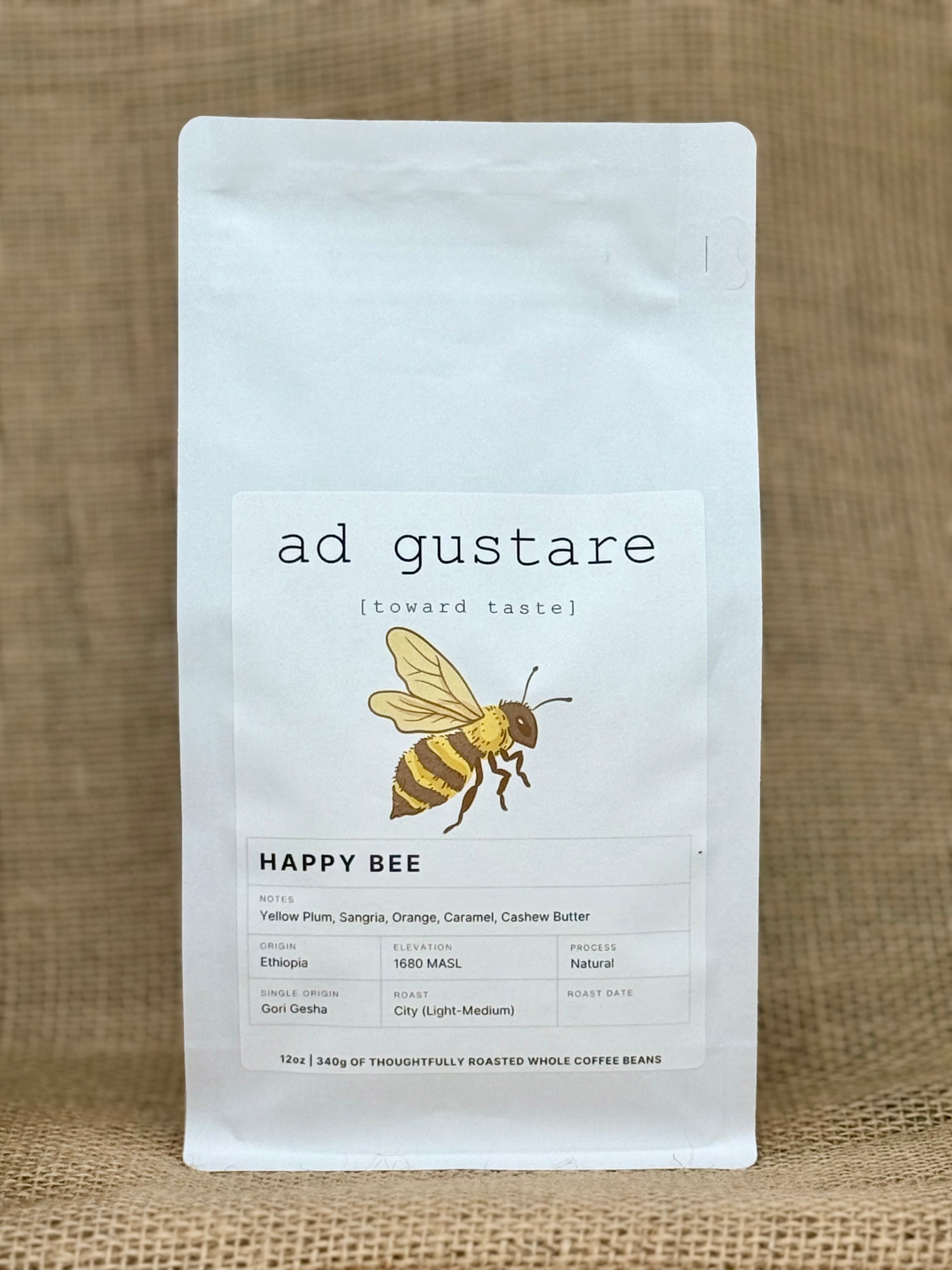 Ad Gustare Happy Bee Ethiopia coffee bag with minimalist white label featuring an illustrated bee, photographed on burlap. Front view